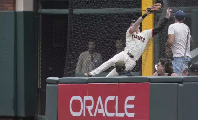 San Francisco Giants right fielder Mike Yastrzemski catches a fly ball hit into foul territory by Pittsburgh Pirates' Jack Suwinski during the eighth inning of a baseball game Wednesday, July 30, 2025, in San Francisco. (AP Photo/Godofredo A. Vásquez)