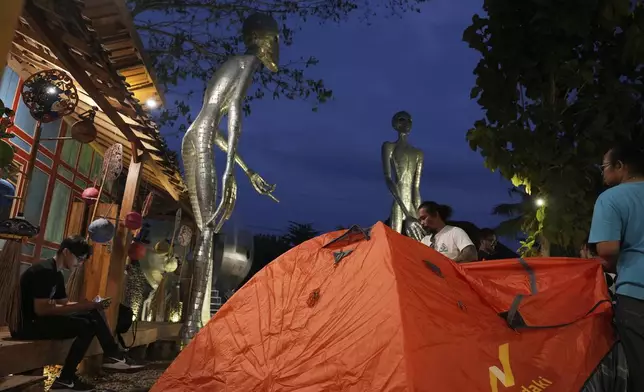 Participants set up their tent during the "UFO Camp," held as a part of Indonesia UFO Festival, in Yogyakarta, Indonesia, Thursday, July 24, 2025. (AP Photo/Dita Alangkara)
