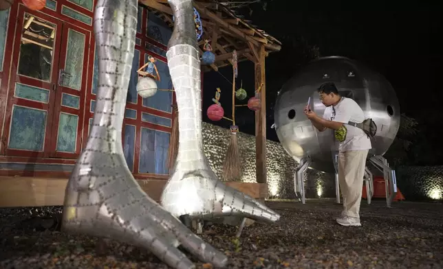 A participant takes photos near the statue of an alien, during the Indonesia UFO Festival, in Yogyakarta, Indonesia, Thursday, July 24, 2025. (AP Photo/Dita Alangkara)