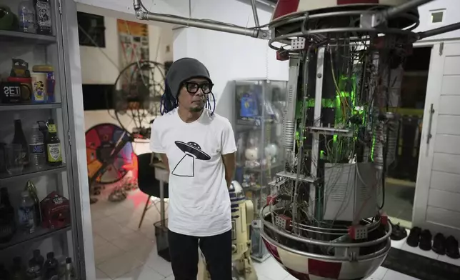 Artist and UFO enthusiast Venzha Christ who is also the Director of Indonesia Space Science Society, an organization established as a platform for space enthusiasts focused on promoting astronomy and space exploration for general public, stands near what he said to be a DIY radio astronomy receiver installed at his residence in Yogyakarta, Indonesia, Saturday, July 26, 2025. (AP Photo/Dita Alangkara)