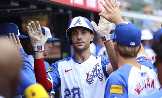 Atlanta Braves' Matt Olson (28) high-fives teammates in the dugout after hitting a solo home run in the third inning of a baseball game against the Baltimore Orioles, Saturday, July 5, 2025, in Atlanta. (AP Photo/Colin Hubbard)