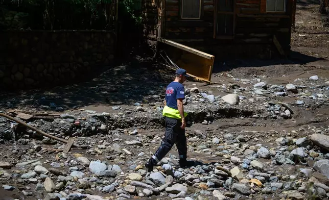 Ruidoso Fire Rescue members comb the Rio Ruidoso on Wednesday afternoon, July 9, 2025, in Ruidoso, N.M., looking for potential victims after flash floods hit the area yesterday. (AP Photo/Roberto E. Rosales)