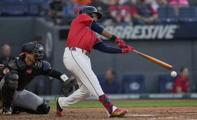 Cleveland Guardians' Jose Ramirez hits a single in front of Baltimore Orioles catcher Alex Jackson, left, in the fourthinning of a baseball game in Cleveland, Monday, July 21, 2025. (AP Photo/Sue Ogrocki)