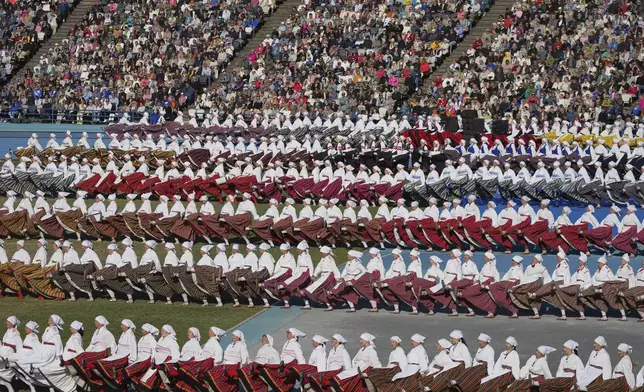 Participants perform during the Estonian Song and Dance Celebration "Iseoma" at the Kalev Stadium in Tallinn, Estonia, Friday, July 4, 2025. (AP Photo/Sergei Grits)