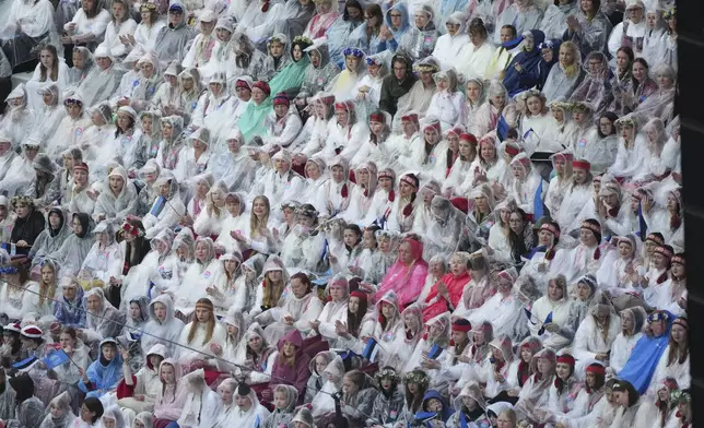 Choir singers take part in the Estonian Song Festival, part of the "Iseoma" Song and Dance Celebration, at the Song Festival Grounds in Tallinn, Estonia, Saturday, July 5, 2025. (AP Photo/Sergei Grits)