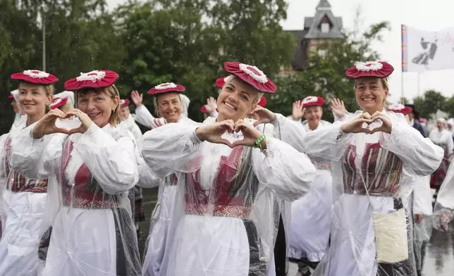 People pose as they attend the "Iseoma" Song and Dance Celebration, in Tallinn, Estonia, Saturday, July 5, 2025. (AP Photo/Sergei Grits)