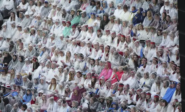 Choir singers take part in the Estonian Song Festival, part of the "Iseoma" Song and Dance Celebration, at the Song Festival Grounds in Tallinn, Estonia, Saturday, July 5, 2025. (AP Photo/Sergei Grits)