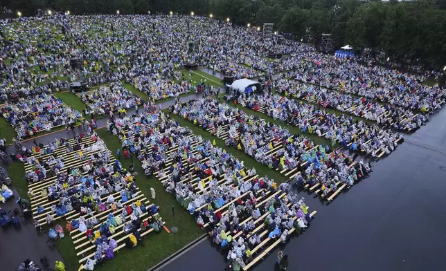 People enjoy the Estonian Song Festival, part of the "Iseoma" Song and Dance Celebration, at the Song Festival Grounds in Tallinn, Estonia, Saturday, July 5, 2025. (AP Photo/Sergei Grits)