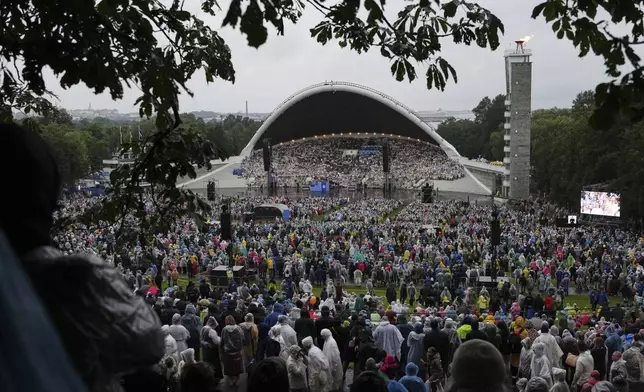 Choir singers take part in the Estonian Song Festival, part of the "Iseoma" Song and Dance Celebration, at the Song Festival Grounds in Tallinn, Estonia, Saturday, July 5, 2025. (AP Photo/Sergei Grits)