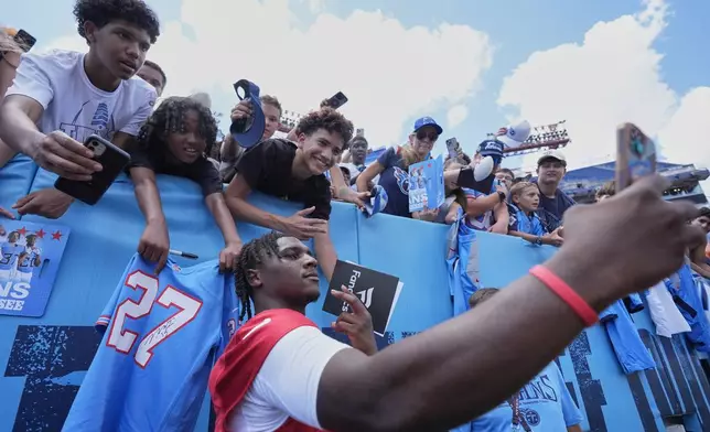 Tennessee Titans quarterback Cam Ward takes a selfie with fans during "Back Together Weekend" at the team's NFL football training camp Saturday, July 26, 2025, in Nashville, Tenn. (AP Photo/George Walker IV)