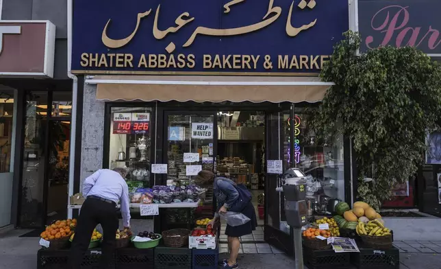 Two shoppers select items at a grocery store in the "Tehrangeles" neighborhood of Los Angeles Tuesday, June 24, 2025. (AP Photo/Jae C. Hong)