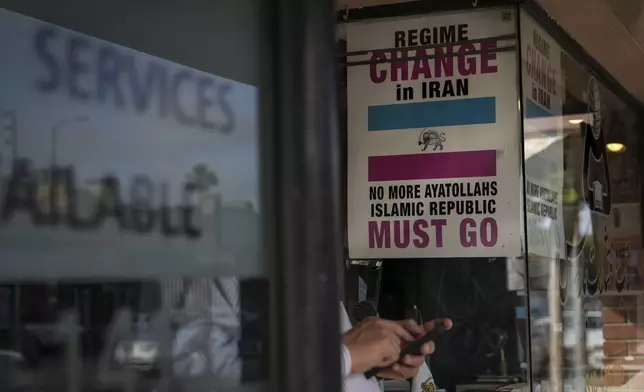 Posters calling for regime change in Iran are displayed in the window of Sam Beykzadeh's bookstore in the "Tehrangeles" neighborhood of Los Angeles Tuesday, June 24, 2025. (AP Photo/Jae C. Hong)