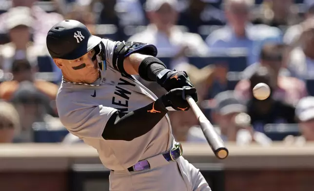 New York Yankees' Aaron Judge hits a sacrifice fly during the seventh inning of a baseball game against the New York Mets, Sunday, July 6, 2025, in New York. (AP Photo/Adam Hunger)