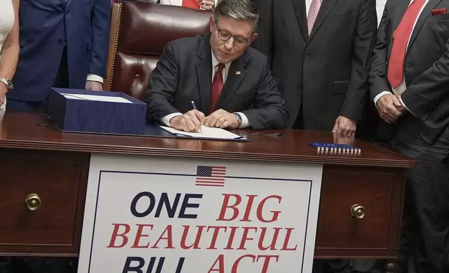 Speaker of the House Mike Johnson, R-La., center, surrounded by fellow Republicans, signs President Donald Trump's signature bill of tax breaks and spending cuts, Thursday, July 3, 2025, at the Capitol in Washington. (AP Photo/Mariam Zuhaib)