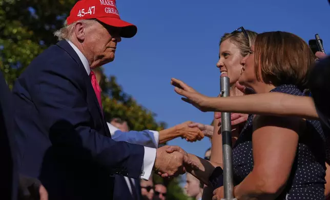 President Donald Trump and first lady Melania Trump greet guests after he signed his signature bill of tax breaks and spending cuts at the White House, Friday, July 4, 2025, in Washington. (AP Photo/Julia Demaree Nikhinson)