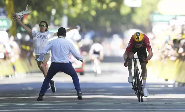 Norway's Jonas Abrahamsen sprints as a protester tries to cross the finish line during the eleventh stage of the Tour de France cycling race over 156.8 kilometers (97.4 miles) with start and finish in Toulouse, France, Wednesday, July 16, 2025. (AP Photo/Thibault Camus)