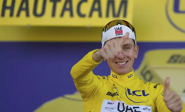 Stage winner Slovenia's Tadej Pogacar celebrates taking the yellow jersey after the twelfth stage of the Tour de France cycling race over 180.6 kilometers (112.2 miles) with start in Auch and finish in Hautacam, France, Thursday, July 17, 2025. (AP Photo/Mosa'ab Elshamy)