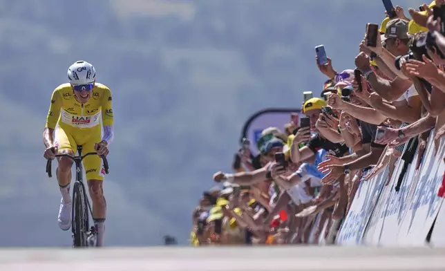 Slovenia's Tadej Pogacar, wearing the overall leader's yellow jersey, wins the thirteenth stage of the Tour de France cycling race, an individual time-trial over 10.5 kilometers (6.5 miles) in the Pyrenees mountains with start in Loudenvielle and finish in Peyragudes, France, Friday, July 18, 2025. (AP Photo/Thibault Camus)