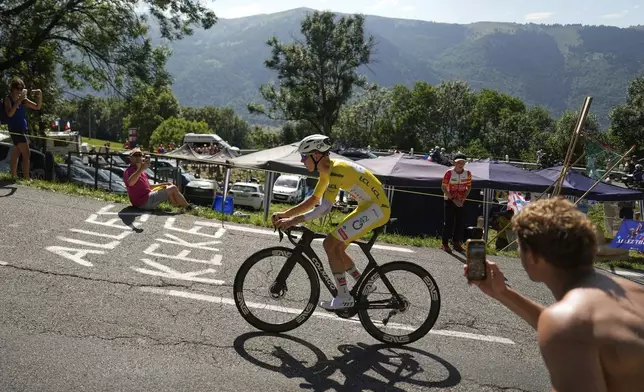 Slovenia's Tadej Pogacar, wearing the overall leader's yellow jersey, climbs to win the thirteenth stage of the Tour de France cycling race, an individual time-trial over 10.5 kilometers (6.5 miles) in the Pyrenees mountains with start in Loudenvielle and finish in Peyragudes, France, Friday, July 18, 2025. (AP Photo/Mosa'ab Elshamy)