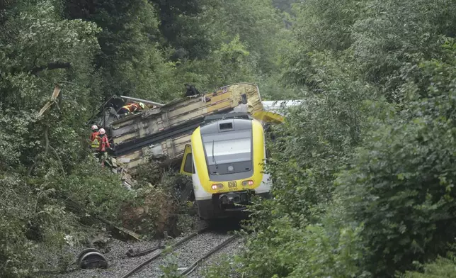 Rescue workers search for passengers in a derailed train, Zwiefaltendorf, Sunday July 27, 2025. (Thomas Warnack/dpa via AP)
