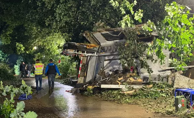 Parts of the derailed regional passenger train lie next to a section of track as police and first responders work at the scene near Riedlingen, Germany, Sunday, July 27, 2025. (Nico Pointner/dpa via AP)