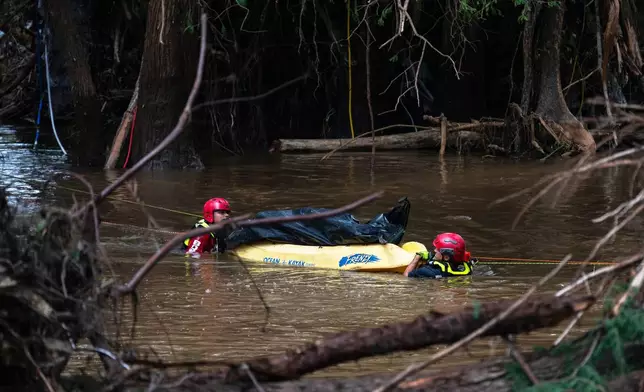 Firefighters from Ciudad Acuña, Mexico, transport a recovered body on the flooded Guadalupe River days after a flash flood swept through the area, Monday, July 7, 2025, in Ingram, Texas. (AP Photo/Eli Hartman)