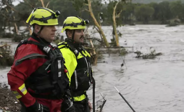 CORRECTS DAY - Kerrville Fire Department first responders scan the banks of the Guadalupe River for individuals swept away by flooding in Ingram, Texas, Friday, July 4, 2025. (Michel Fortier/The San Antonio Express-News via AP)