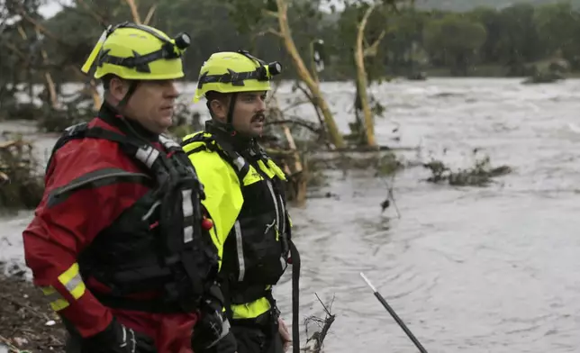 Kerrville Fire Department first responders scan the banks of the Guadalupe River for individuals swept away by flooding in Ingram, Texas, Thursday, July 4, 2025. (Michel Fortier/The San Antonio Express-News via AP)