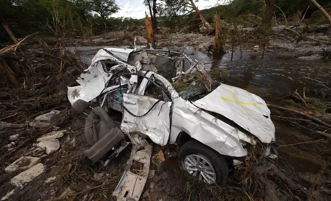 A destroyed vehicle sits next to the Guadalupe River on Wednesday, July 9, 2025, in Hunt, Texas, after a flash flood swept through the area. (AP Photo/Gerald Herbert)
