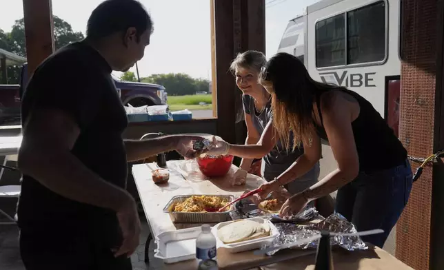 Audrey Ethridge and Briana Virden, right, help feed first responders and volunteers in Comfort, Texas on Thursday, July 10, 2025. (AP Photo/Ashley Landis)