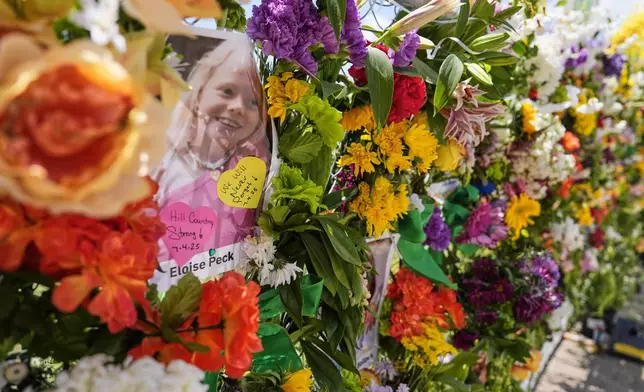 Photographs of flood victims are displayed on a memorial wall in Kerrville, Texas, Thursday, July 10, 2025. (AP Photo/Ashley Landis)