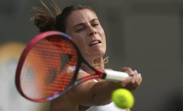 Emma Navarro of the U.S. returns to Mirra Andreeva of Russia during a fourth round women's singles match at the Wimbledon Tennis Championships in London, Monday, July 7, 2025. (AP Photo/Kin Cheung)