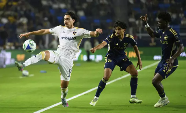 Los Angeles Galaxy forward Matheus Nascimento, left, controls the ball during the second half of an MLS soccer match against the Vancouver Whitecaps Friday, July 4, 2025, in Carson, Calif. (AP Photo/William Liang)