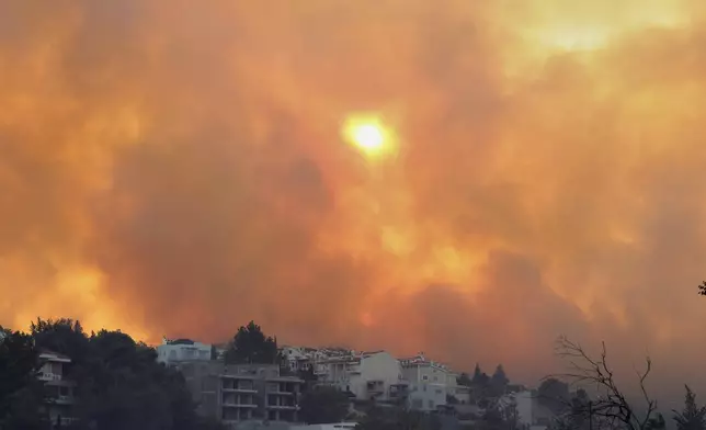 Smoke covers the sky during a wildfire, in the northwestern suburb of Kryoneri, in Athens, Greece, Saturday, July 26, 2025. (AP Photo/Yorgos Karahalis)