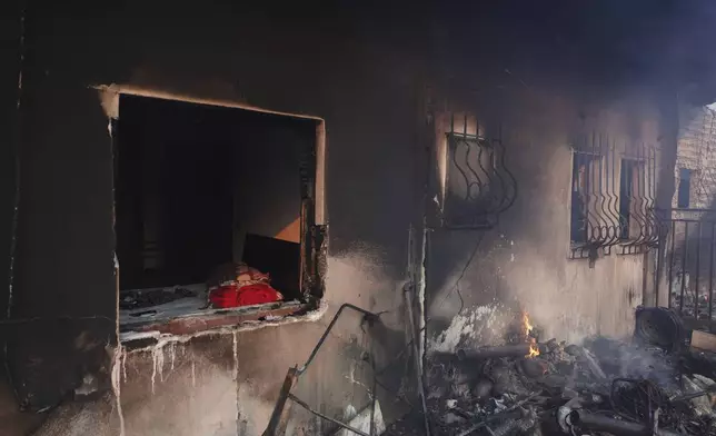Blazes burn a house during a wildfire, in the northwestern suburb of Kryoneri, in Athens, Greece, Saturday, July 26, 2025. (AP Photo/Yorgos Karahalis)