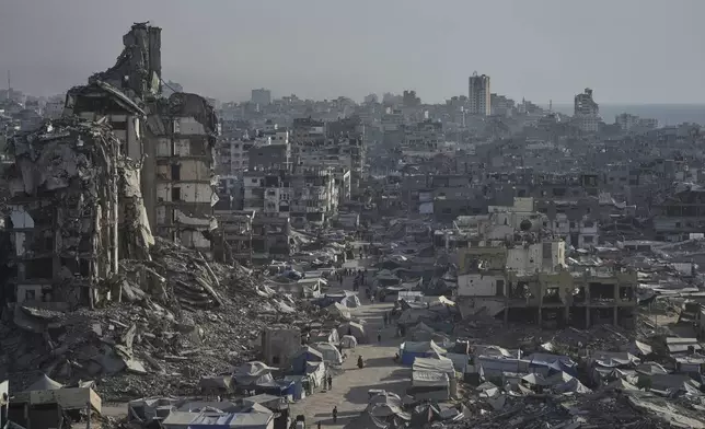 Tents sheltering displaced Palestinians are seen amid war-damaged infrastructure in Gaza City, Thursday, July 17, 2025. (AP Photo/Jehad Alshrafi)