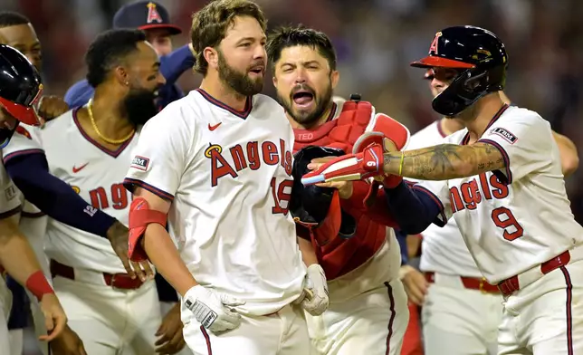 Los Angeles Angels' Nolan Schanuel, center, celebrates with teammates after a walk-off walk during the ninth inning of a baseball game against the Texas Rangers, Monday, July 7, 2025, in Anaheim, Calif. (AP Photo/Jayne Kamin-Oncea)