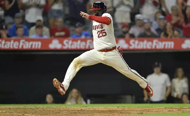 Los Angeles Angels' Travis d'Arnaud (25) scores on a single by Angels' LaMonte Wade Jr. during the seventh inning of a baseball game against the Texas Rangers, Monday, July 7, 2025, in Anaheim, Calif. (AP Photo/Jayne Kamin-Oncea)