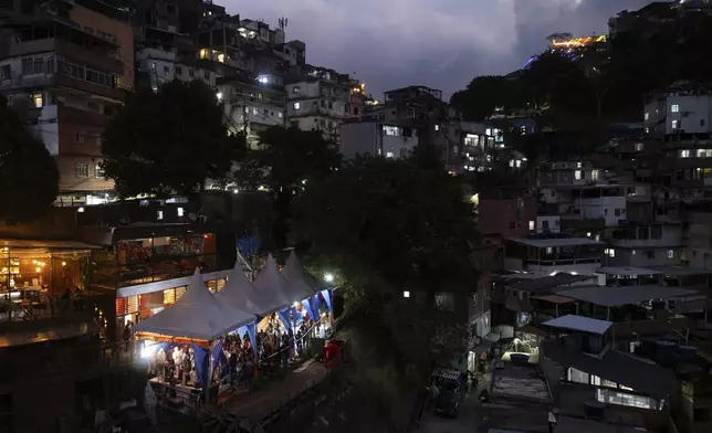 People attend a performance by American vocalist of Hindu devotional music Jeff Kagel during a Tranformation Project yoga class in the Rocinha favela, Rio de Janeiro, Wednesday, July 9, 2025. (AP Photo/Bruna Prado)