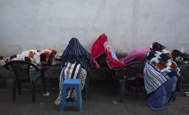 Residents remain outside their homes after dozens of earthquakes and aftershocks were recorded in a matter of hours in Palin, Guatemala, early Wednesday, July 9, 2025. (AP Photo/Moises Castillo)