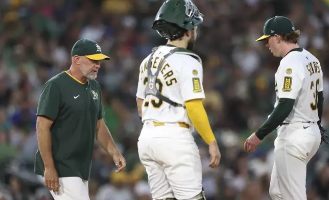 Athletics manager Mark Kotsay, left, pulls Athletics pitcher JP Sears, right during the fifth inning of a baseball game against the Seattle Mariners, Monday, July 28, 2025, in West Sacramento, Calif. (AP Photo/Scott Marshall)