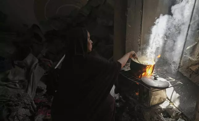 Naima Abu Ful cooks for her family in their home in the Shati refugee camp in Gaza City on Wednesday, July 23, 2025. (AP Photo/Jehad Alshrafi)