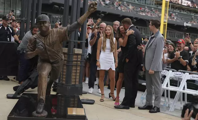 Former Chicago White Sox pitcher Mark Buehrle, second from right, and family embrace after the team unveiled a statue of Buehrle as they celebrate their 2005 World Series-winning team before a baseball game against the Cleveland Guardians, Friday, July 11, 2025, in Chicago. (AP Photo/Melissa Tamez)