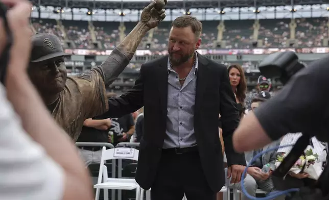 The Chicago White Sox unveil a statue of former pitcher Mark Buehrle, center, as they celebrate their 2005 World Series-winning team before a baseball game against the Cleveland Guardians, Friday, July 11, 2025, in Chicago. (AP Photo/Melissa Tamez)