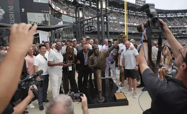 Former Chicago White Sox pitcher Mark Buehrle, center, poses with his 2005 teammates after his statue was unveiled before a baseball game against the Cleveland Guardians, Friday, July 11, 2025, in Chicago. (AP Photo/Melissa Tamez)