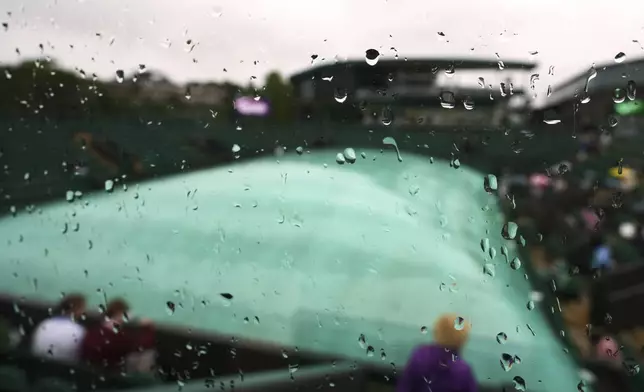 Raindrops run down a window as court 3 is covered to protect as the start of play is delayed during the Wimbledon Tennis Championships in London, Wednesday, July 2, 2025.(AP Photo/Kirsty Wigglesworth)