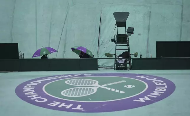 The courts remain covered as rain falls on day three at the Wimbledon Tennis Championships in London, Wednesday, July 2, 2025. (AP Photo/Alastair Grant)