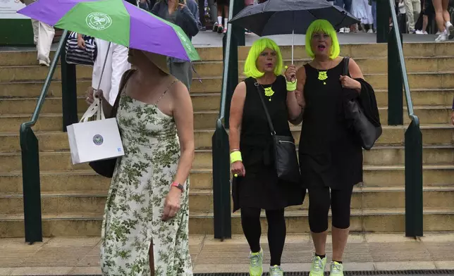 Spectators arrive as the start of play is delayed due to rain during the Wimbledon Tennis Championships in London, Wednesday, July 2, 2025.(AP Photo/Kirsty Wigglesworth)