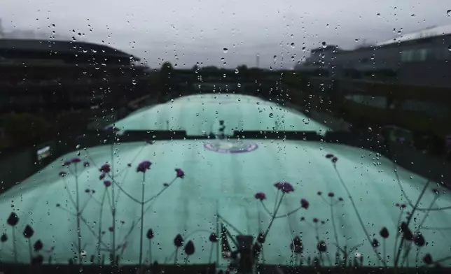 Raindrops run down a window as the outside courts are covered and the start of play is delayed due to rain during the Wimbledon Tennis Championships in London, Wednesday, July 2, 2025.(AP Photo/Kirsty Wigglesworth)