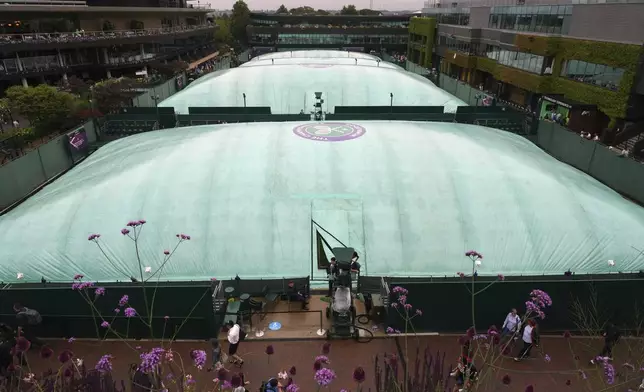 The outside courts are covered as the start of play is delayed due to rain during the Wimbledon Tennis Championships in London, Wednesday, July 2, 2025.(AP Photo/Kirsty Wigglesworth)